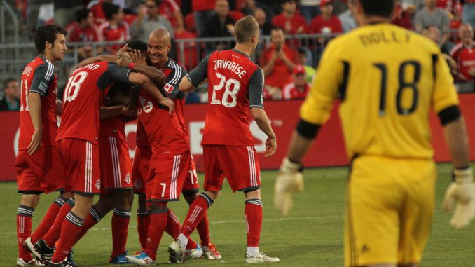 Whitecaps goalkeeper Jay Nolly watches TFC players celebrate Nick Soolsma's successful penalty kick in the second half
