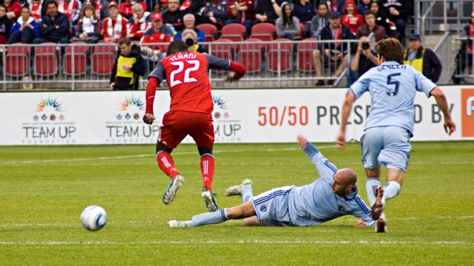 Kansas City's Aurelien Collin (centre) knocks the ball away from TFC's Tony Tchani