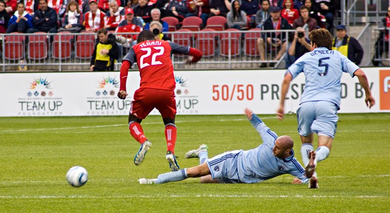 Kansas City's Aurelien Collin (centre) knocks the ball away from TFC's Tony Tchani