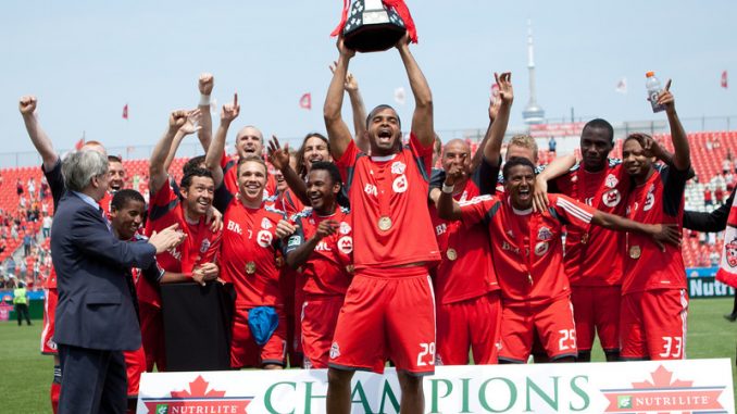 With his teammates behind him, TFC Captain Maicon Santos hoists the Voyageurs Cup in celebration of winning the NCC