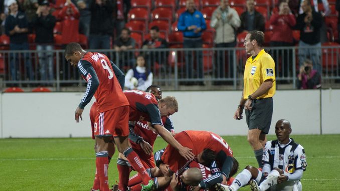Toronto FC players jump on striker Danny Koevermans in celebration of his goal in the first half (John Lucero)