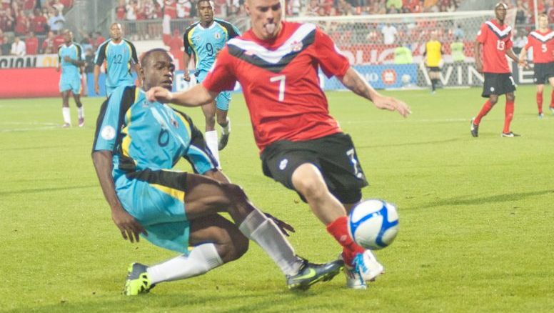 Canadian midfielder Ian Hume (left) avoids a tackle from St. Lucian defender Nathan Justin (right)