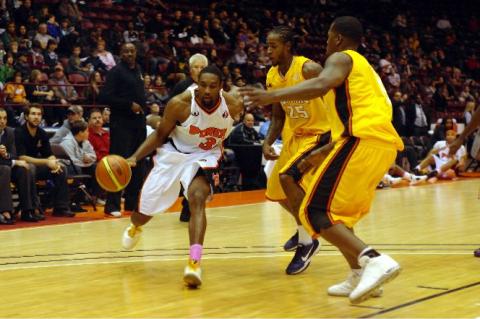 Oshawa Power small forward Akeem Wright dribbles past two London Lightning players on Thursday night at General Motors Centre