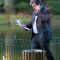 Oliver Letwin standing by a public bin while talking on mobile and having papers in one hand