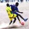 A Goozaga football team player (in yellow) challenging a Young Star player (in Blue) at Rumbek Stadium [©Gurtong]