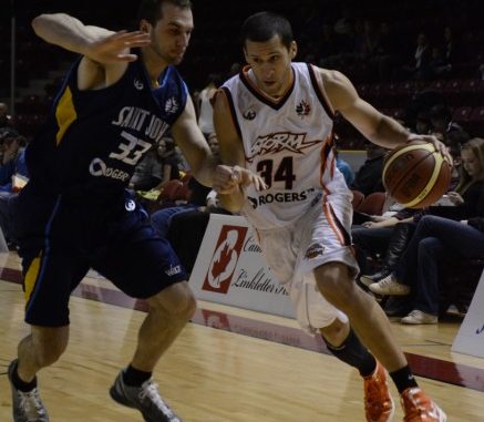 Summerside Storm small forward Chris Cayole (right) drives past Saint John Mill Rats forward Steve DeLuca