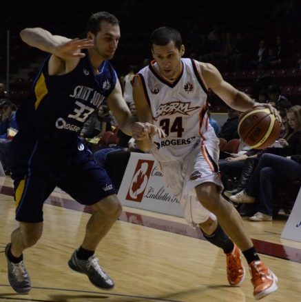 Summerside Storm small forward Chris Cayole (right) drives past Saint John Mill Rats forward Steve DeLuca