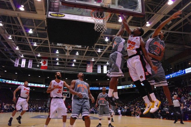 Oshawa Power small forward Akeem Wright muscles past a pair of Moncton Miracles for a dunk on Thursday night at the General Motors Centre