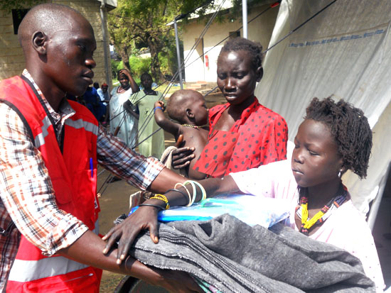 A Red Cross staff handing over boarding items to an Internaly displaced family at the Juba Hospital [©Gurtong]
