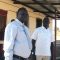 (L-R) Commissioner Lokai Iko Loteyo and Paul Oleyo of Land Mark Construction Company pose at the construction site [©Gurtong]