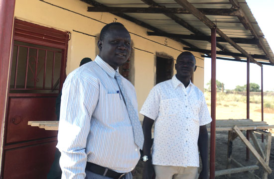 (L-R) Commissioner Lokai Iko Loteyo and Paul Oleyo of Land Mark Construction Company pose at the construction site [©Gurtong]
