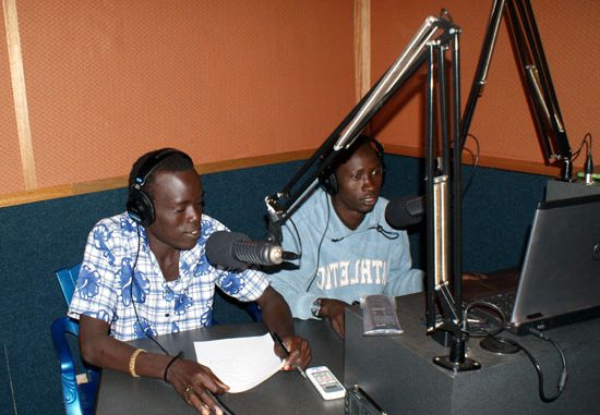 Some of the new “Voice of Freedom” radio station presenters reading news to listeners in Magwi County [©Gurtong]