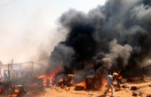 A man tries to extinguish the hot fire at Jow market in Wau [©Gurtong]