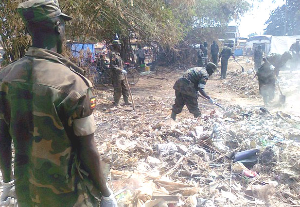 Uganda People’s Defence Force personnel cleaning Yambio market in commemoration of Army Week Day [©Gurtong]