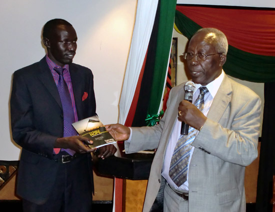 Professor Sam Ongeri (right) hands over the new book to Mr. Garang Malong (left) to mark its official launch in Nairobi [©Gurtong]