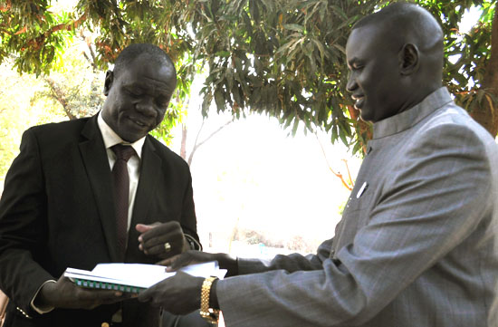 WBGS Minister of Finance Moriss Yol Akol (left) handing over the State Transitional Constitution to Governor Rizik Zackaria Hassan [©Gurtong]