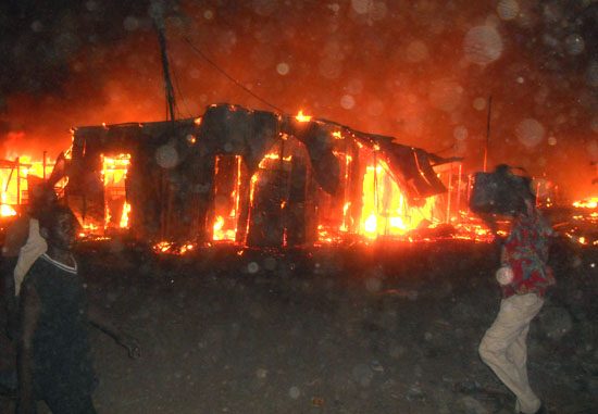 Traders try to extinguish the fierce fire from spreading to other business premises at Konyokonyo market in Juba [©Gurtong]