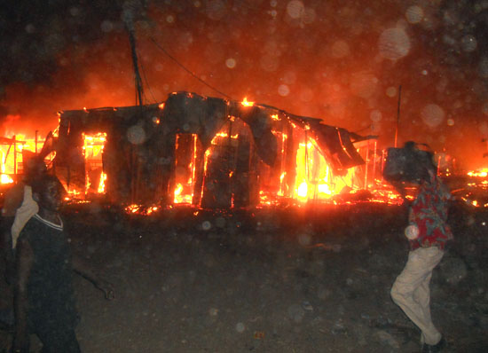 Traders try to extinguish the fierce fire from spreading to other business premises at Konyokonyo market in Juba [©Gurtong]