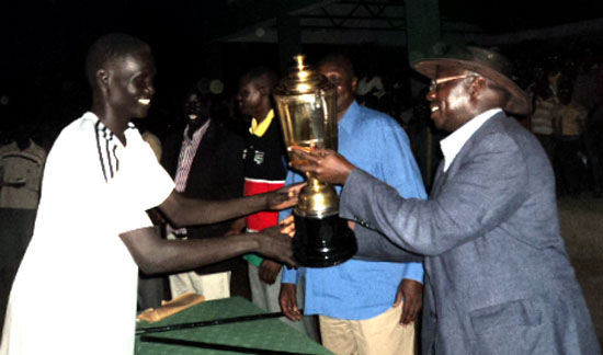 A Volcano team player receives the golden and coveted trophy from the national minister of Youths and Sports Dr. Cirino Hiteng [©Gurtong/ Peter Lokale]