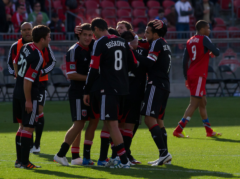 DC United Captain Dwayne De Rosario celebrates a 2-0 win with his teammates against his old team at BMO Field. In the background frustrated Toronto FC forward Ryan Johnson walks off the pitch (JP Dhanoa) DC United Captain Dwayne De Rosario celebrates a 2-0 win with his teammates against his old team at BMO Field. In the background frustrated Toronto FC forward Ryan Johnson walks off the pitch (JP Dhanoa)