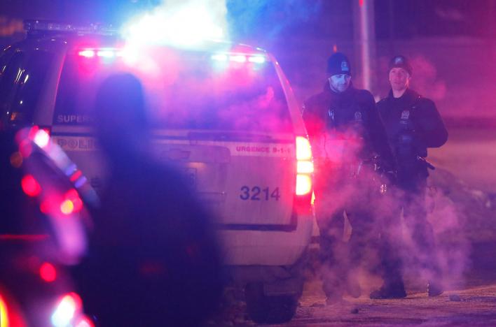 Police officers are seen near a mosque after a shooting in Quebec City
