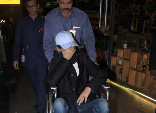 A wheelchair-bound Irrfan Khan hides his face as the paparazzi spots him at the airport