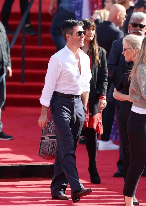 simon cowell walks tall in his elevator shoes