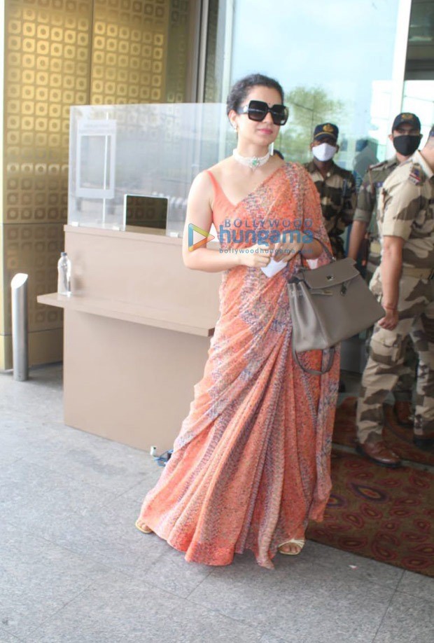kangana ranaut leaves for manali after testing negative for covid-19; dons orange saree at the airport