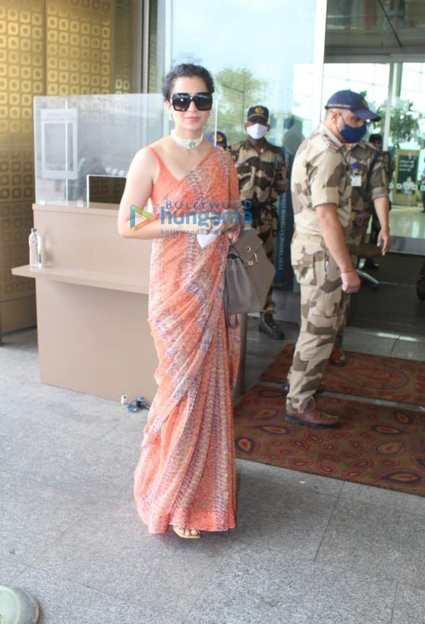 kangana ranaut leaves for manali after testing negative for covid-19; dons orange saree at the airport